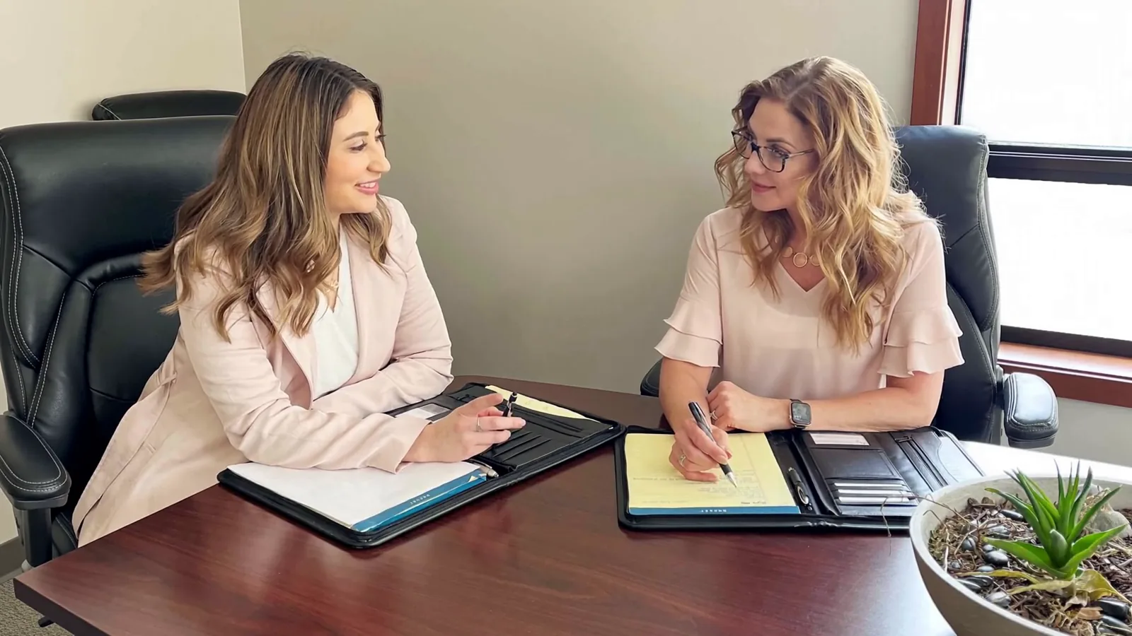 Annabel Cobane and Nicole Dupré reviewing a case file at the conference table